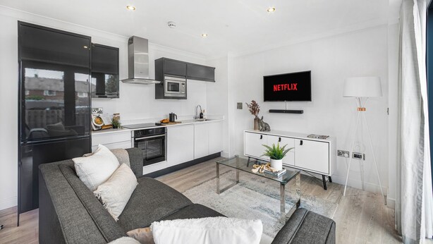 A modern apartment with a kitchen, living room, and a flat-screen TV displaying 'NETFLIX'. - York Suite (Chester)