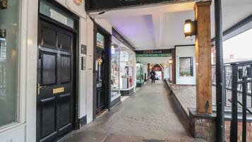 A corridor with shops on either side, including a barbershop.