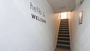 A staircase with a 'hello & welcome' sign on the wall. - Kingsley Loft (Chester)