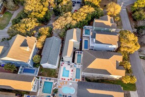 An aerial view of a residential area with multiple houses, a swimming pool, and a tennis court. - Palmetto Breeze Coastal Retreat w Private Pool (Surfside Beach)