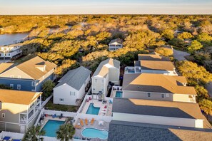 A residential area with houses, a swimming pool, and a lake in the background. - Palmetto Breeze Coastal Retreat w Private Pool (Surfside Beach)
