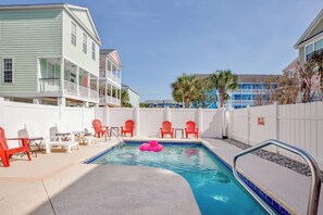A swimming pool with lounge chairs and a poolside area. - Palmetto Breeze Coastal Retreat w Private Pool (Surfside Beach)