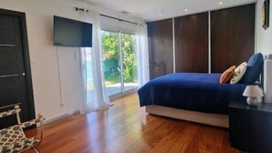 A bedroom with a bed, a chair, a TV, and a window. - VILLA La Mazal, Bord de Mer, Balnéo, Piscine Clim (Sète)