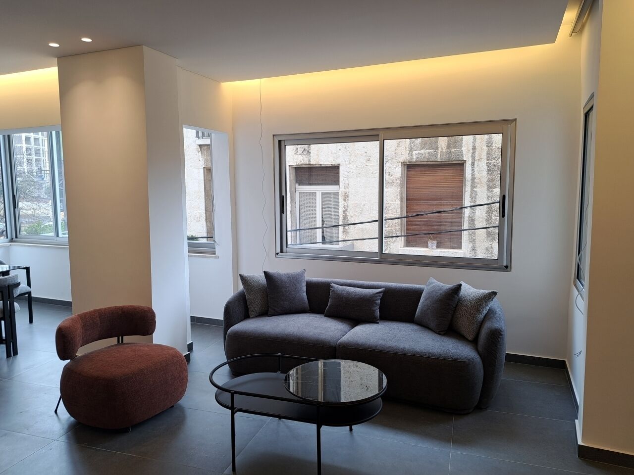 A modern living room with a sofa, a red chair, and a coffee table.