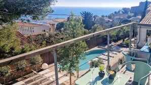 A balcony with a pool, outdoor seating, and a view of the sea and town. - VILLA des Rêves, Superbe Vue, Swimming Pool, Prox center (Sète)