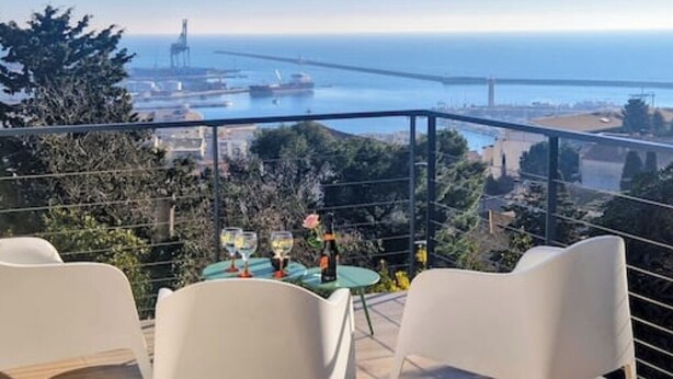 A terrace with a table set for two, overlooking a coastal view with a bridge and port. - VILLA des Rêves, Superbe Vue, Swimming Pool, Prox center (Sète)