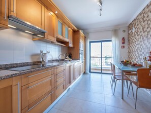 Eine moderne Küche mit Holzausstattung, einer Granitabdeckung und einem Essbereich mit Tisch und Stühlen.