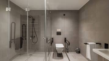 Un baño moderno con ducha de vidrio, inodoro y bañera.