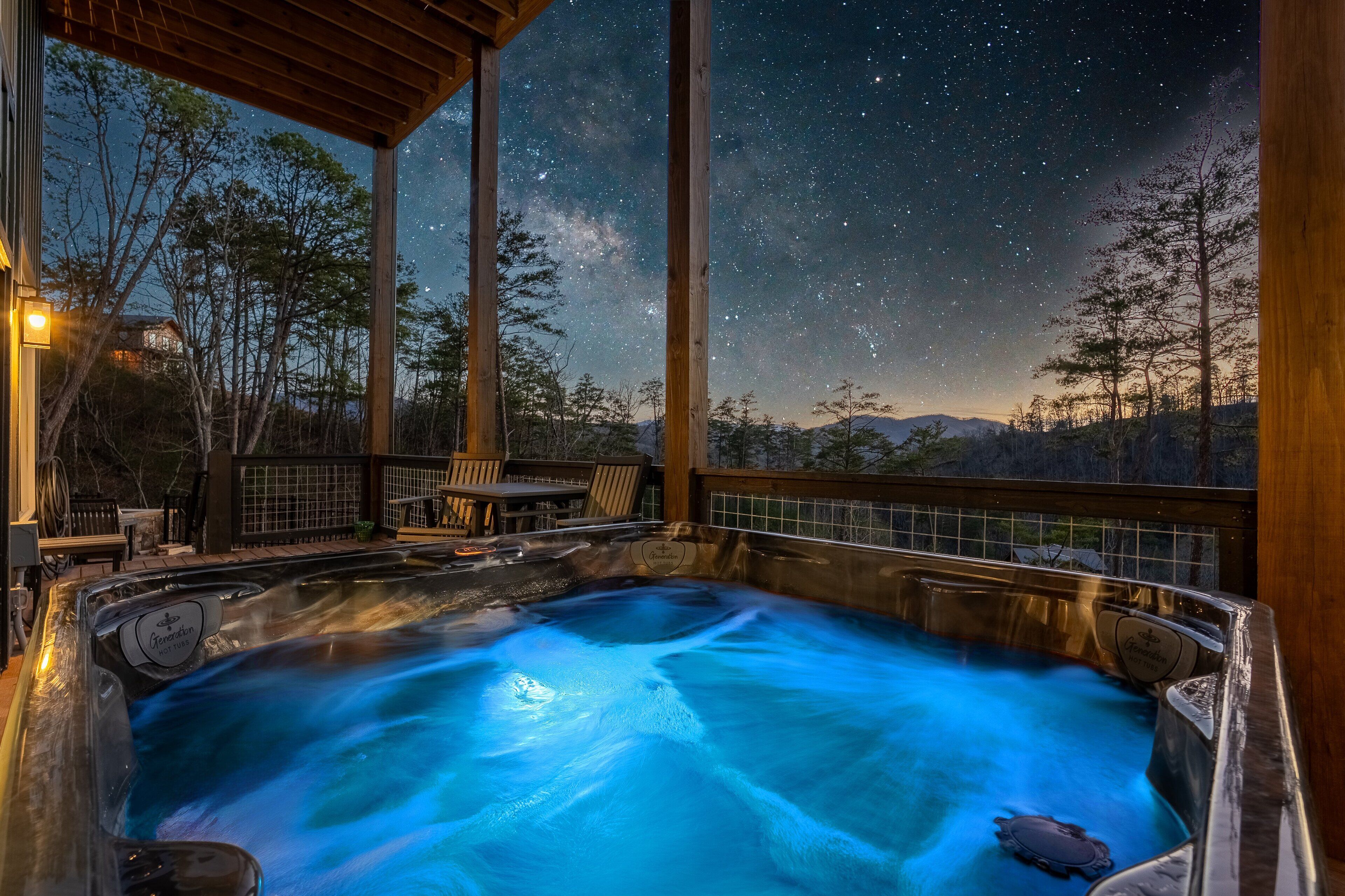 A hot tub under a wooden pergola with a starry night sky view.