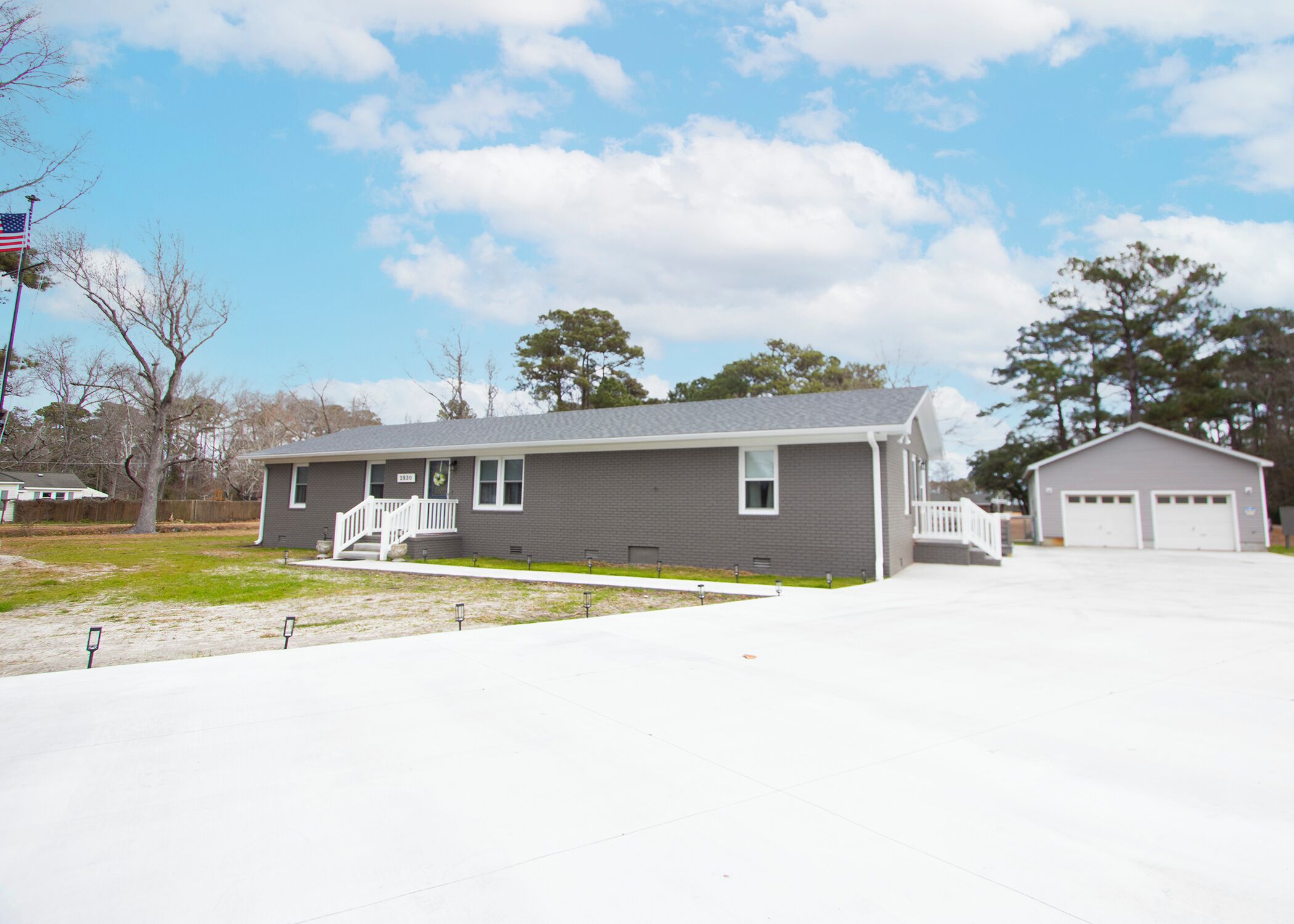 A single-story house with a front porch, a garage, and a well-maintained lawn.