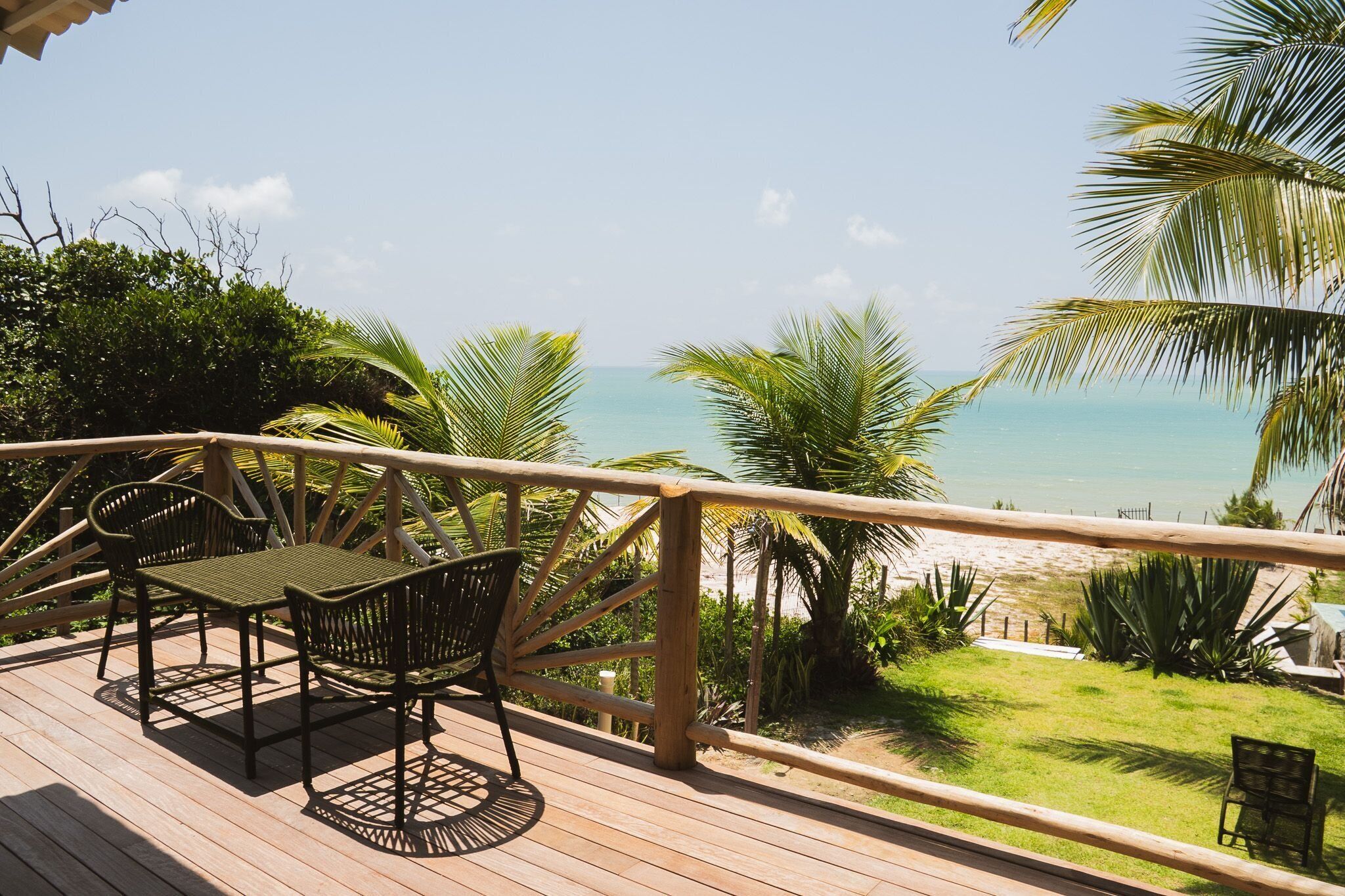 Una terraza de madera con mobiliario exterior con vistas a la playa.