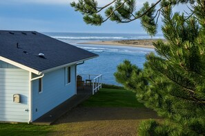 A house with a balcony overlooking a beach and ocean.