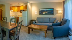 A compact living space with a dining area, a sofa, and a kitchen.