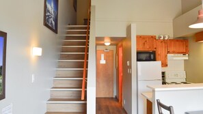 A kitchen with wooden cabinets, a microwave, a stove, and a refrigerator.