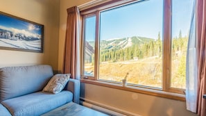 Ein Zimmer mit großem Fenster und Blick auf eine Berglandschaft.