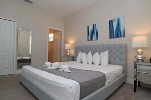 A neatly arranged bedroom with a large bed, two bedside tables with lamps, and two abstract wall art pieces. - 176cc-balmoral Resort 6 Bedroom Home (Haines City)
