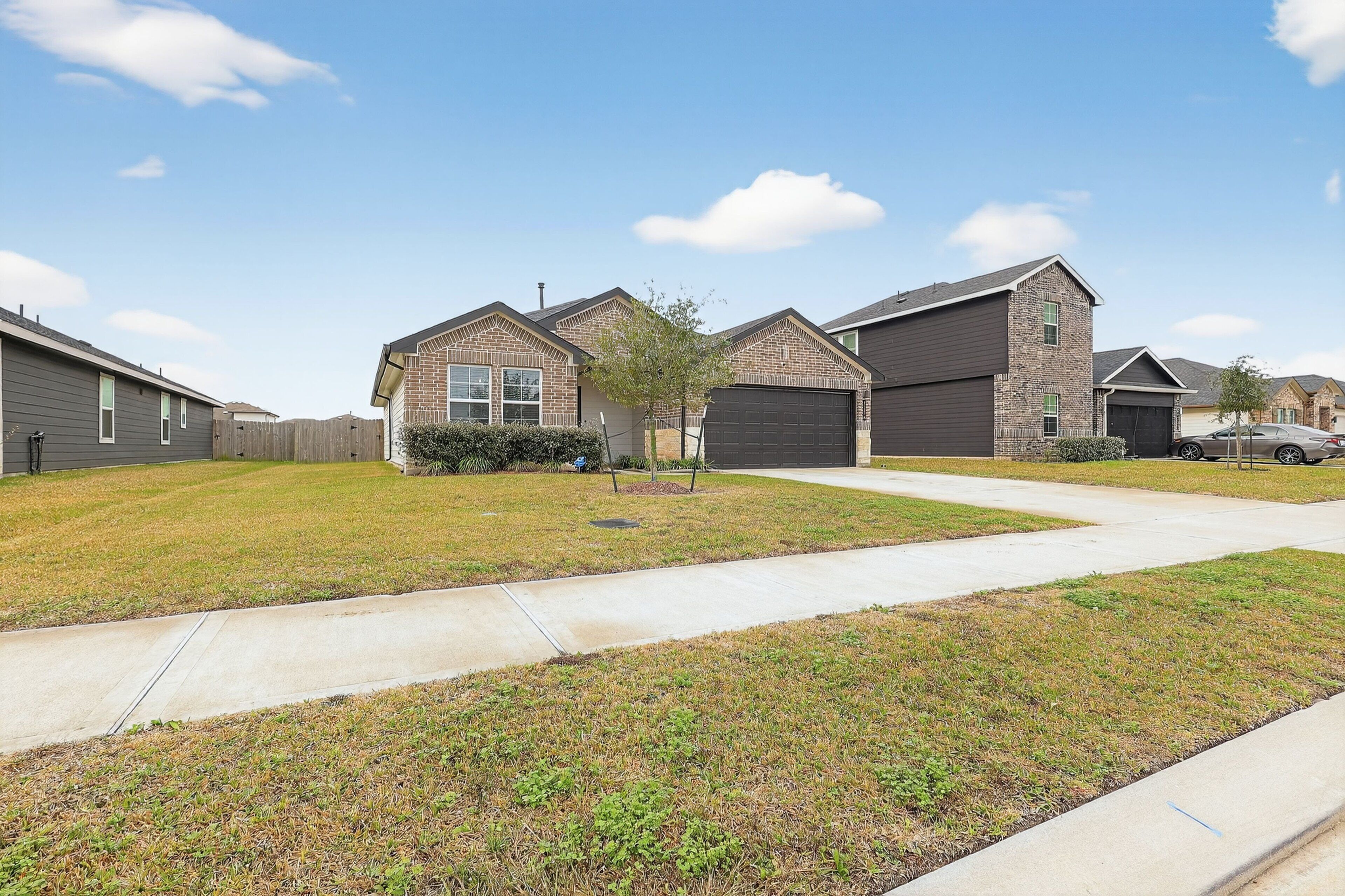 A residential area with houses, a driveway, and a sidewalk.