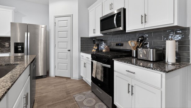 A modern kitchen with stainless steel appliances, white cabinetry, and a granite countertop. - Sunset Creek Sanctuary - Spacious Family Home 3 Bedroom Home (Richmond)