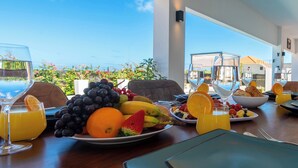 A breakfast setting with a table set for two, featuring plates of fruit, glasses of orange juice, and a view of the outdoors. - Charming 2-bedroom villa with AC in peaceful Grote Berg (Grote Berg)
