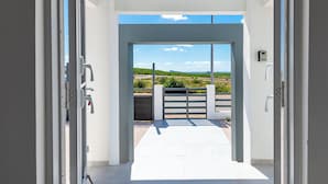 An open doorway leading to a balcony with a view of a rural landscape. - Charming 2-bedroom villa with AC in peaceful Grote Berg (Grote Berg)