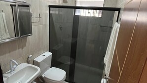 A modern bathroom with a glass-enclosed shower, a white sink, and a toilet. - flatportodegalinhas  (Ipojuca)