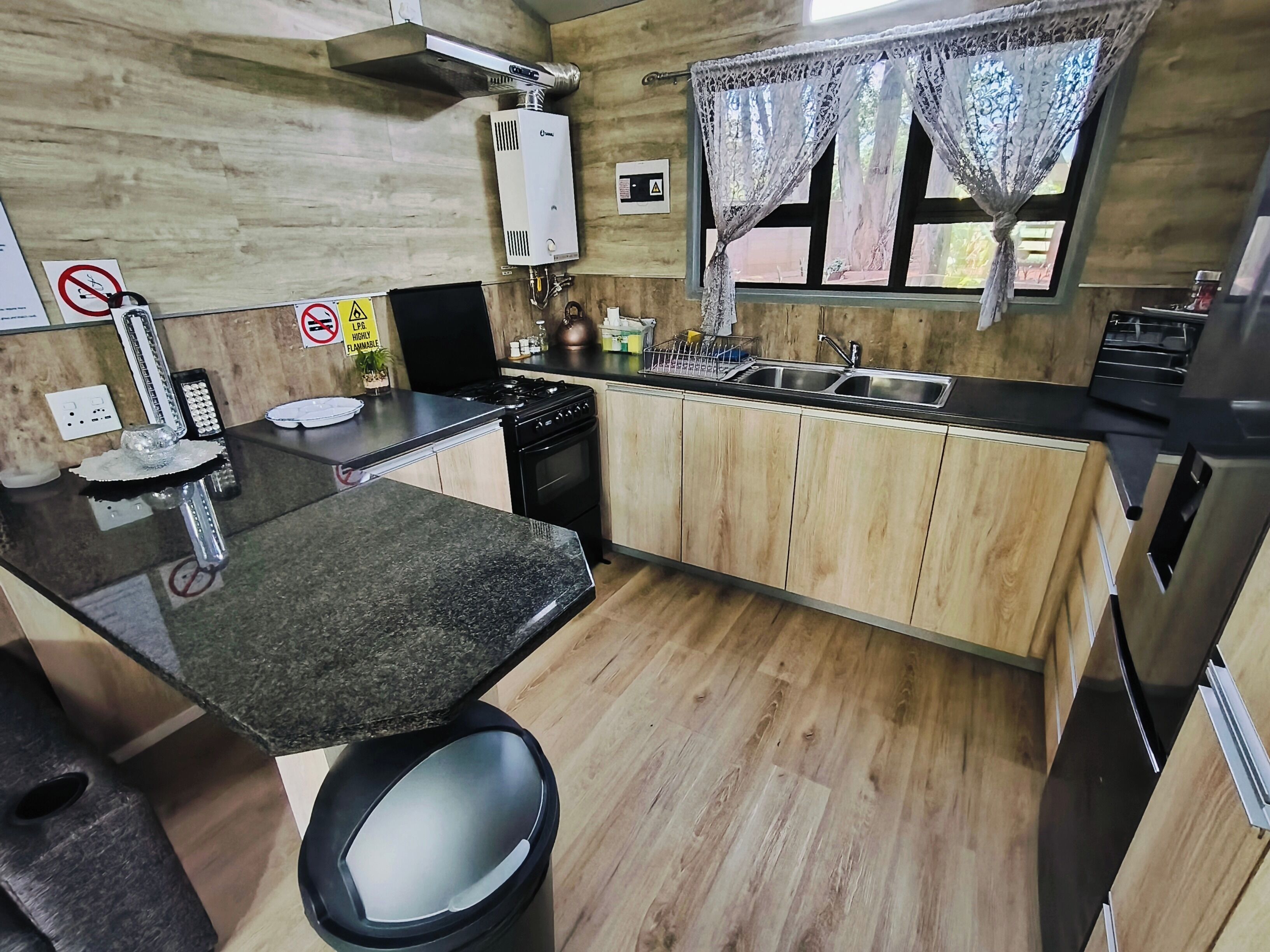 A modern kitchen with a central island, stainless steel appliances, and wooden cabinetry.