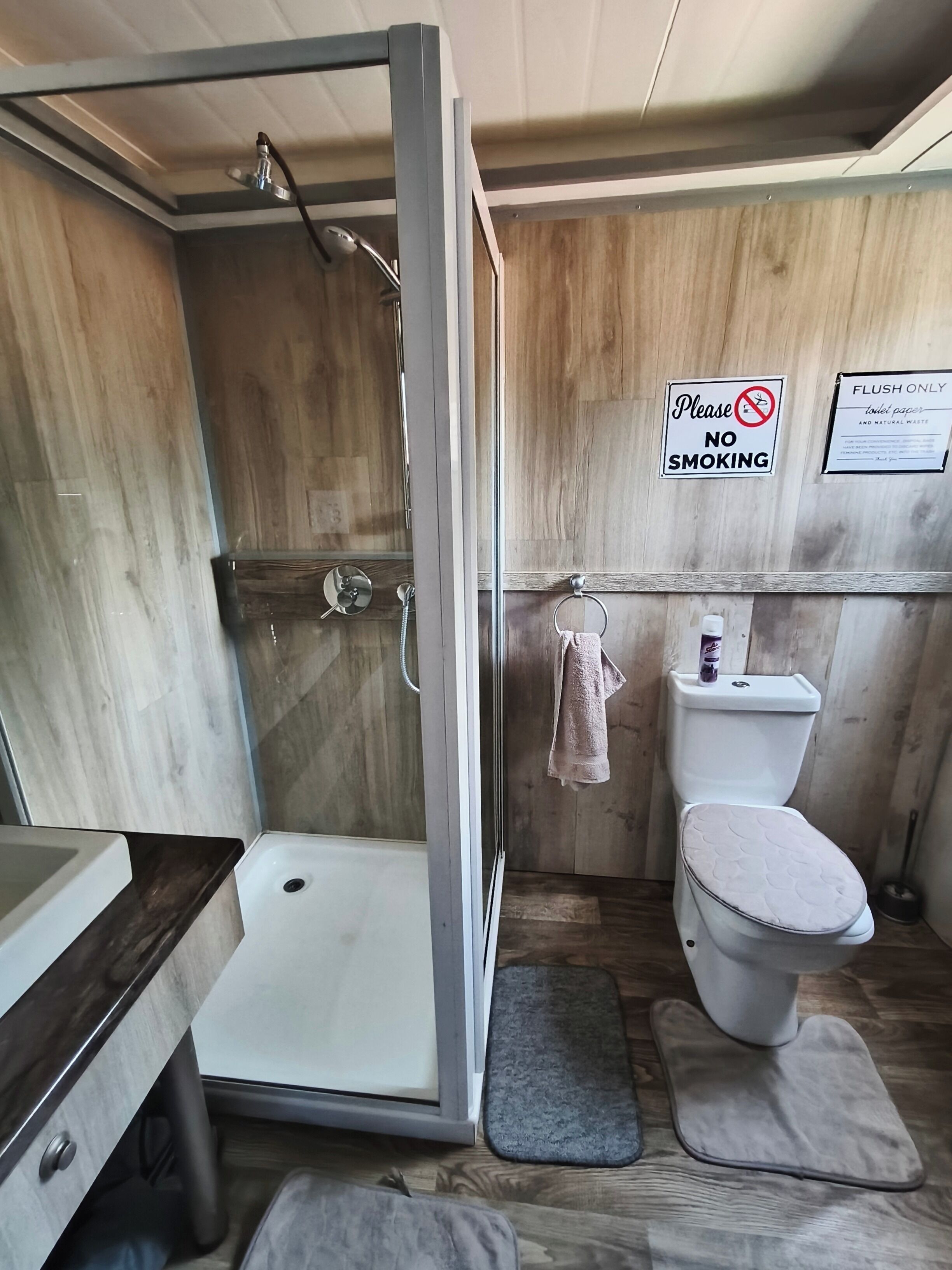 A compact bathroom with a shower, toilet, and sink.