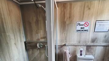 A compact bathroom with a shower, toilet, and sink.