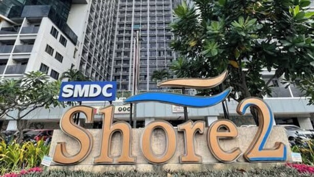 Un moderno grattacielo con un cartello che riporta 'SMDC Shore2'.