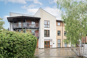 A modern building with a flat roof, multiple windows, and a sign for 'Anarchy Lounge.' - 2 Bedroom Flat Free Parking Close to Gatwick (West Sussex)