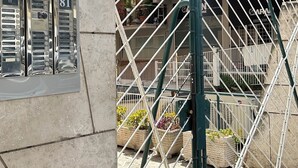 A gated entrance with a metal gate and a building with a brick facade in the background. - Vatican YH (Roma)