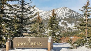 A sign for Snow Creek Resort surrounded by snow-covered trees and mountains. - Fairway Front Luxury with Sweeping Mountain Views | 4BR (Mammoth Lakes)