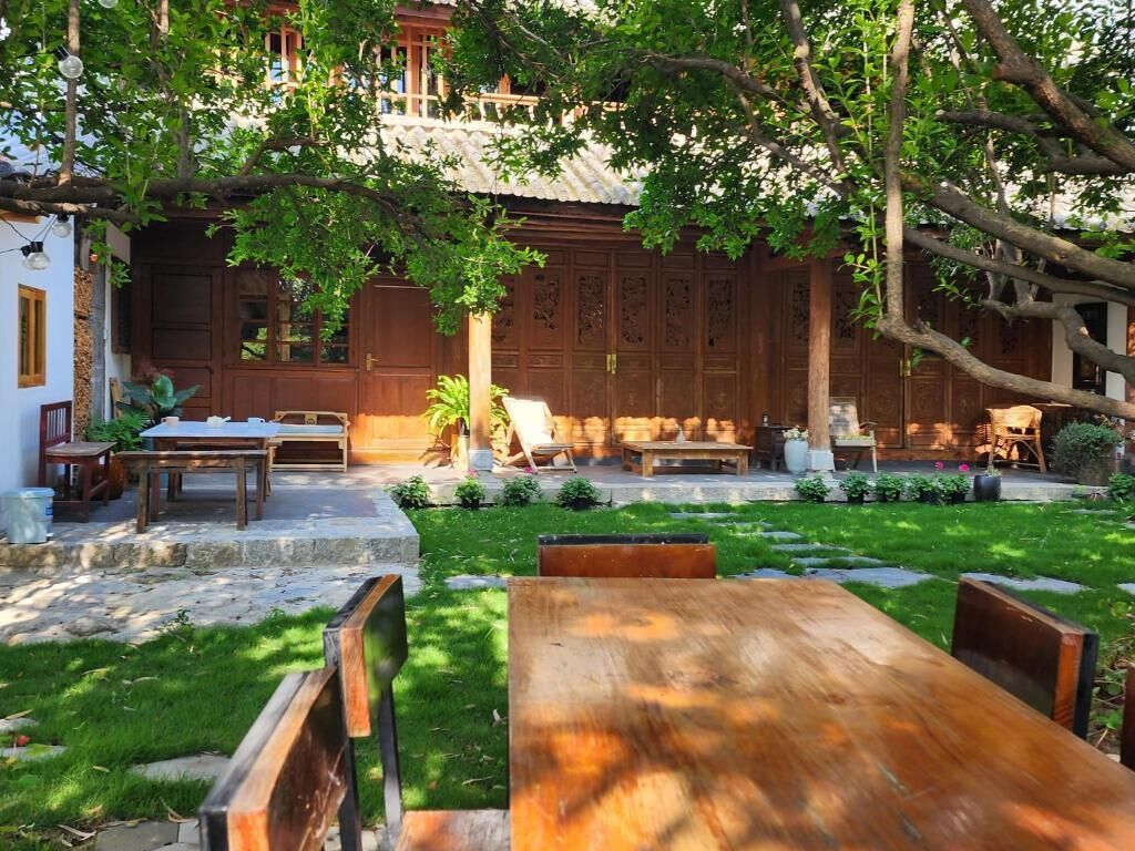 A traditional wooden building with a courtyard, stone steps, and outdoor furniture.