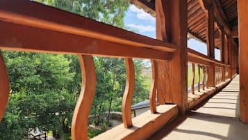 Un balcón de madera con vistas a un jardín exuberante.