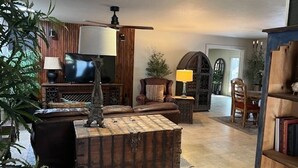 A cozy living room with a wooden coffee table, a television, and a ceiling fan. - Spacious 2-Bedroom Ranch Style Home in Sun Lakes Private Golf Community (Sun Lakes)