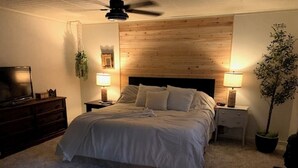 A bedroom with a bed, two bedside tables with lamps, a TV on a dresser, and a ceiling fan. - Spacious 2-Bedroom Ranch Style Home in Sun Lakes Private Golf Community (Sun Lakes)