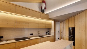 A modern kitchen with wooden cabinetry, a stainless steel sink, and a built-in oven. - Apartment 'Alpino' with Balcony and Wi-Fi (Livigno)