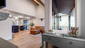 A spacious living area with a large window, a wooden ceiling, and a cozy seating arrangement. - Moose Mgmt at Upper Main 301 (Park City)