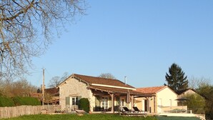 A stone house with a tiled roof, a covered porch, and a swimming pool. - New : Holiday home "Bazeille Haut" with private swimming pool and beautiful view (Saint-Avit-Sénieur)