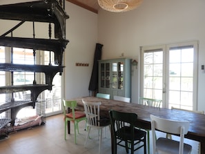 Ein Essbereich mit Holztisch, Stühlen, einem Schrank und einer Treppe.