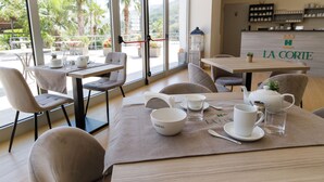 A café with tables set for dining, a visible menu board, and a view of the outdoors. - park hotel la corte & spa (Palma Campania)
