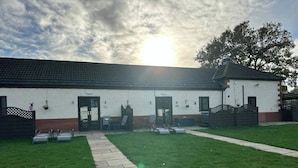 A building with a tiled roof, a paved entrance, and a grassy lawn. - The Tack Room With Hot Tub (Doncaster)