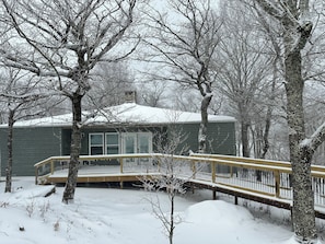A snow-covered residential area with a house, a wooden deck, and leafless trees. - SW-59 Deaver's Delight  Newly remodeled (Beech Mountain)