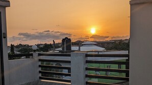 A balcony with a view of a sunset over a cityscape. - Luxery 3-bedroom villa with ACs in a secure and assessable neighborhood in Limbe (Limbe)