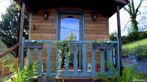 Une cabane en bois avec un balcon, une porte et une fenêtre.