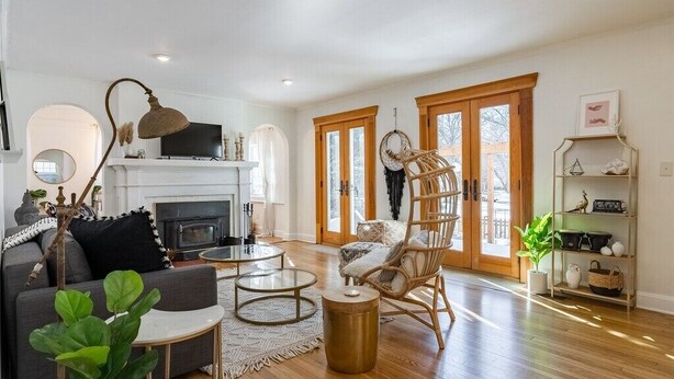 A living room with a fireplace, a sofa, a coffee table, and a wicker chair.