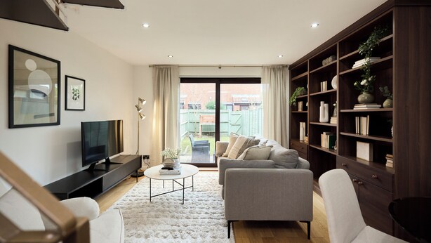 A living room with a sofa, a coffee table, a TV, and a bookshelf. - Poplar Garden Townhouse (London)