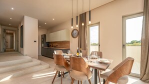 A modern dining area with a table set for four, a kitchen in the background, and a staircase leading to another level. - Villa Suton u Zatonu Zadarvillas (Nin)