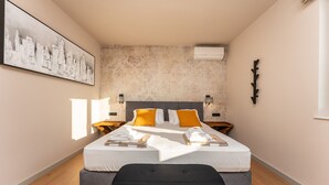 A modern hotel room with a large bed, two bedside tables, a bench, and a cityscape painting on the wall. - Villa Suton u Zatonu Zadarvillas (Nin)