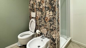 A bathroom with a toilet, bidet, and a shower area. - Domo House 3 (Domodossola)